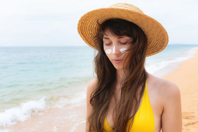 Portrait of young woman wearing hat at beach