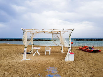 Lifeguard hut on beach against sky