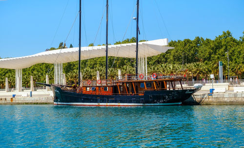 Sailboats moored in sea against clear sky