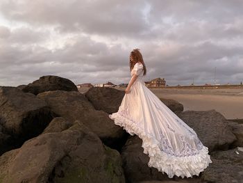 Bride walking on beach rocks 