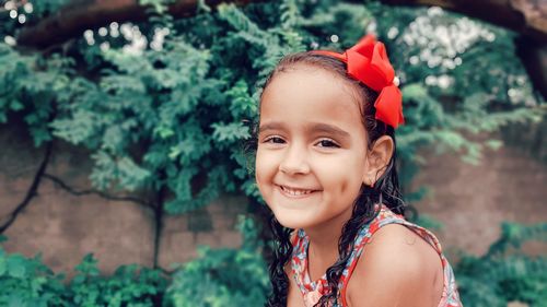 Portrait of smiling girl against trees