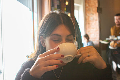 Young woman drinking coffee at home