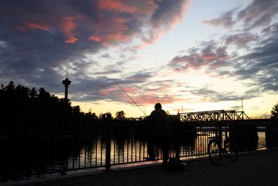 Silhouette of people against cloudy sky