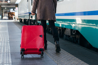 Young tourist girl walking and dragging luggage suitcase bag