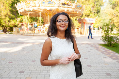 Portrait of young woman standing in city