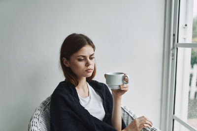 Portrait of young woman drinking coffee