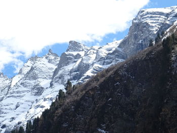 Low angle view of snowcapped mountains against sky