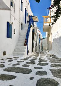 Road amidst houses against clear sky