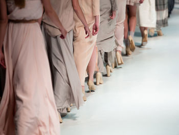 Low section of fashion models walking on runway