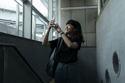 Young woman looking away while standing in corridor