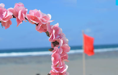 Fabric pink flower crown in the background of private beach in bali, indonesia