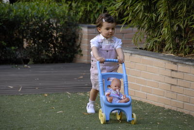 Cute girl walking with baby stroller