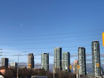 Modern buildings in city against clear blue sky