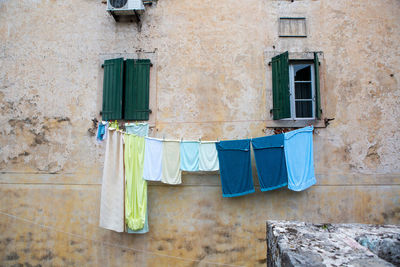 Multi-colored linen is dried outside the window of an old house in montenegro