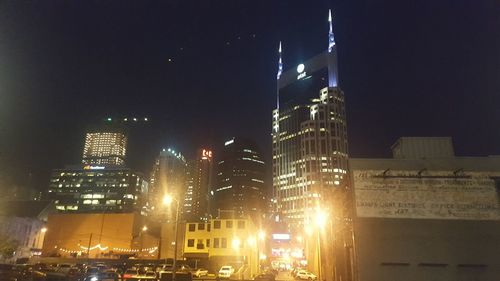 Illuminated cityscape against sky at night