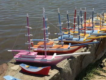 Toy boats on retaining wall by lake