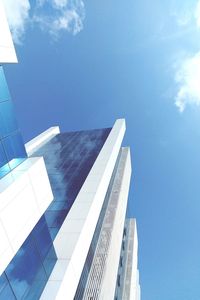 Low angle view of skyscrapers against blue sky