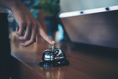 Close-up of hand holding eyeglasses on table
