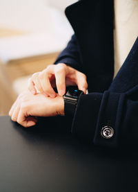 Midsection of person using smart watch on table