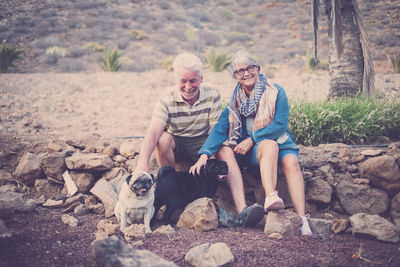 Senior couple with dogs on rocks
