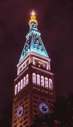 Low angle view of illuminated building against sky at night