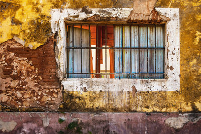 Old window and colorful grungy house