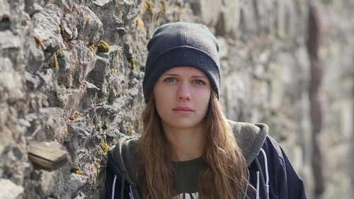 Portrait of young woman wearing hat standing outdoors