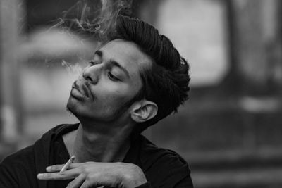 Portrait of young man smoking outdoors