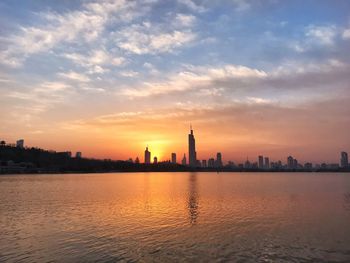 Silhouette of buildings in city during sunset