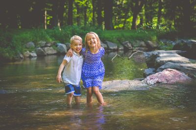 Happy children standing in river