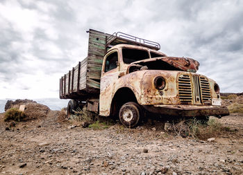 Abandoned vintage car against sky