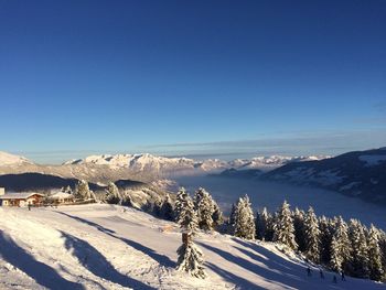 Scenic view of snowcapped mountains against blue sky