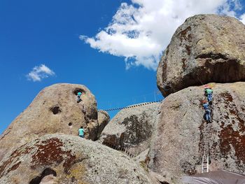 Low angle view of man on rock against sky