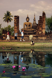 Group of people by large buddha statue