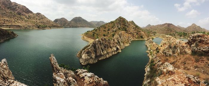 Panoramic view of river amidst mountains against sky