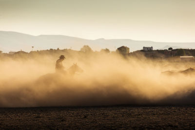 Dust on land against clear sky during sunset