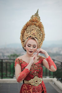 Portrait of smiling young woman with cloth of bali  standing against sky