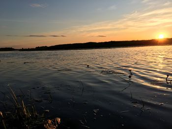 Scenic view of lake against sky during sunset