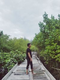 Full length of man walking on footpath against sky