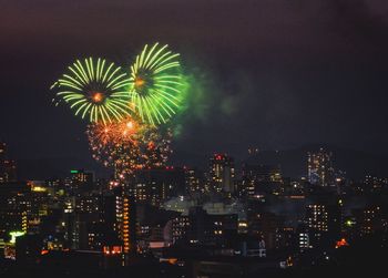 Firework display in city at night