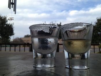 Close-up of beer glass on table against sky