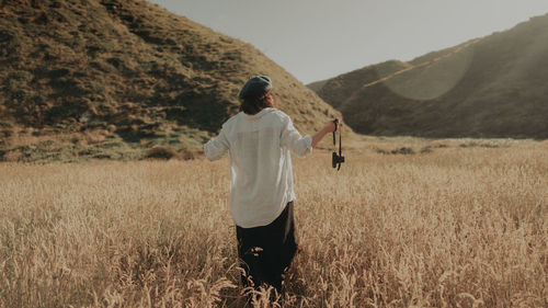 Man standing on field against mountain