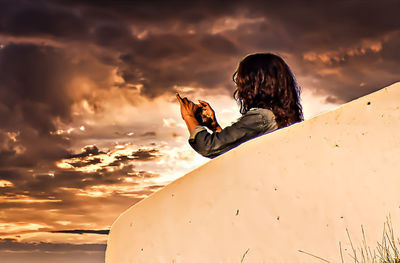 Man with dog in background during sunset