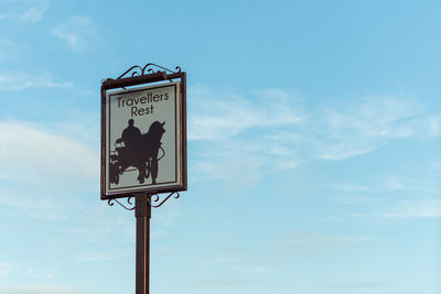 Low angle view of road sign against sky