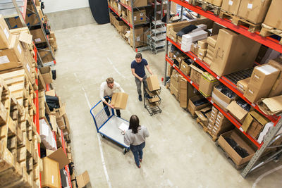 High angle view of coworkers working together in distribution warehouse