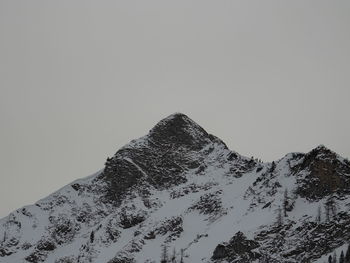 Low angle view of snowcapped mountain against clear sky