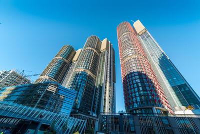 Low angle view of modern buildings against clear blue sky