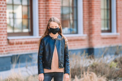 Girl wearing mask while standing outdoors