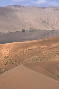 1161 sumu barun jaran lake in badain jaran desert-dark water reflecting cloudy sky and dunes. china.