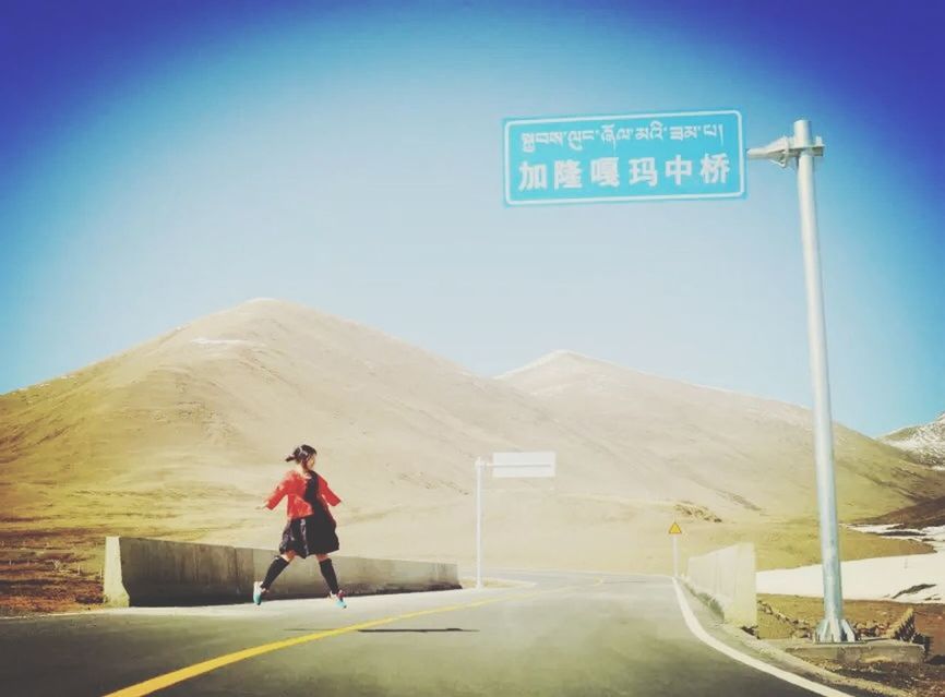 transportation, clear sky, blue, road, full length, copy space, the way forward, mountain, road sign, rear view, land vehicle, lifestyles, communication, men, leisure activity, mode of transport, sign, bicycle